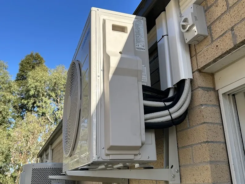Mitsubishi Electric split system outdoor condenser on rendered brick wall